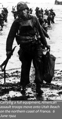 image of solider carrying gear at Utah beach