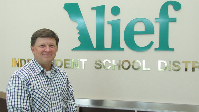 Superintendent HD Chambers stands in front of Alief sign