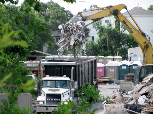 debris dumped from a crane into a truck
