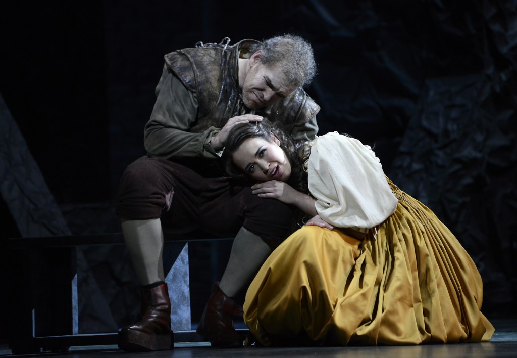 Rigoletto is sitting and Gilda is kneeling with her head on her father's lap