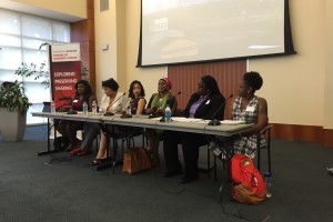 A panel of women sits at a table speaking into microphones about how women's issues fit within the Black Lives Matter movement.