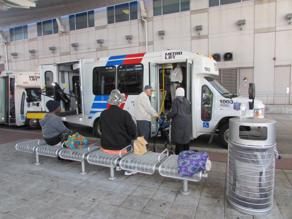 MetroLift customers board paratransit buses outside Metro's downtown headquarters.  