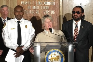 Houston Mayor Annise Parker speaks at a podium during a press conference. She is joined by interim Houston Fire Chief Rodney West (L) and Congressman Al Green (R).