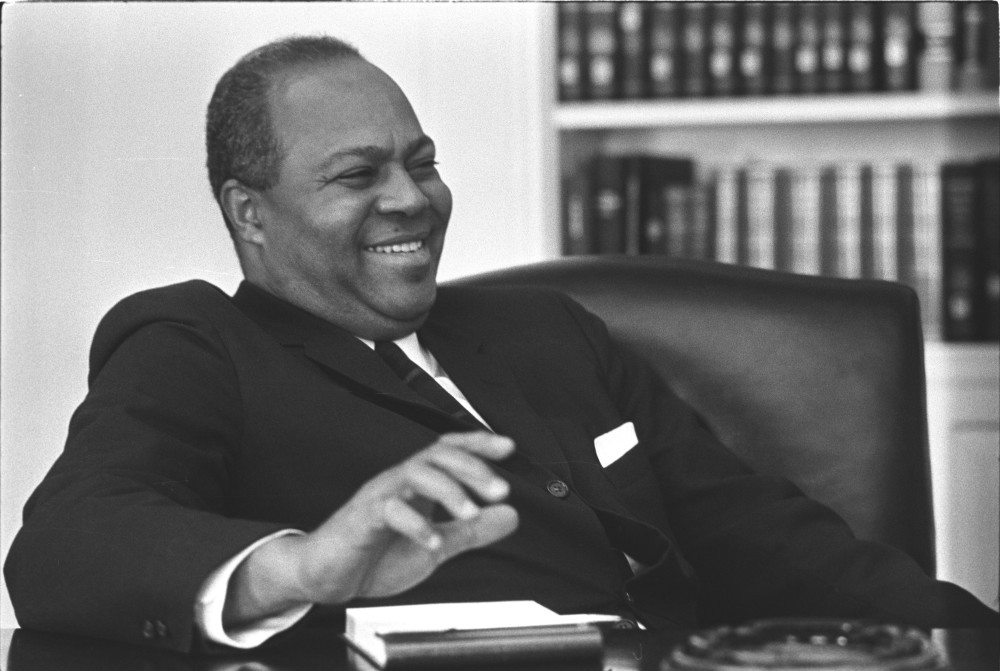 James Farmer laughing and smiling, leaning back in a chair