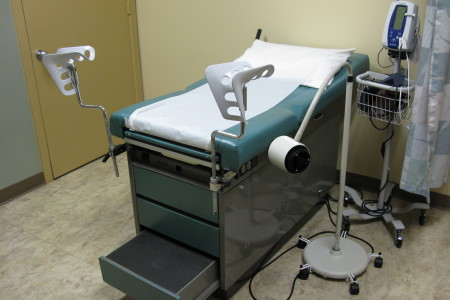 hospital photo of a patient room and gynecological stirrups chair