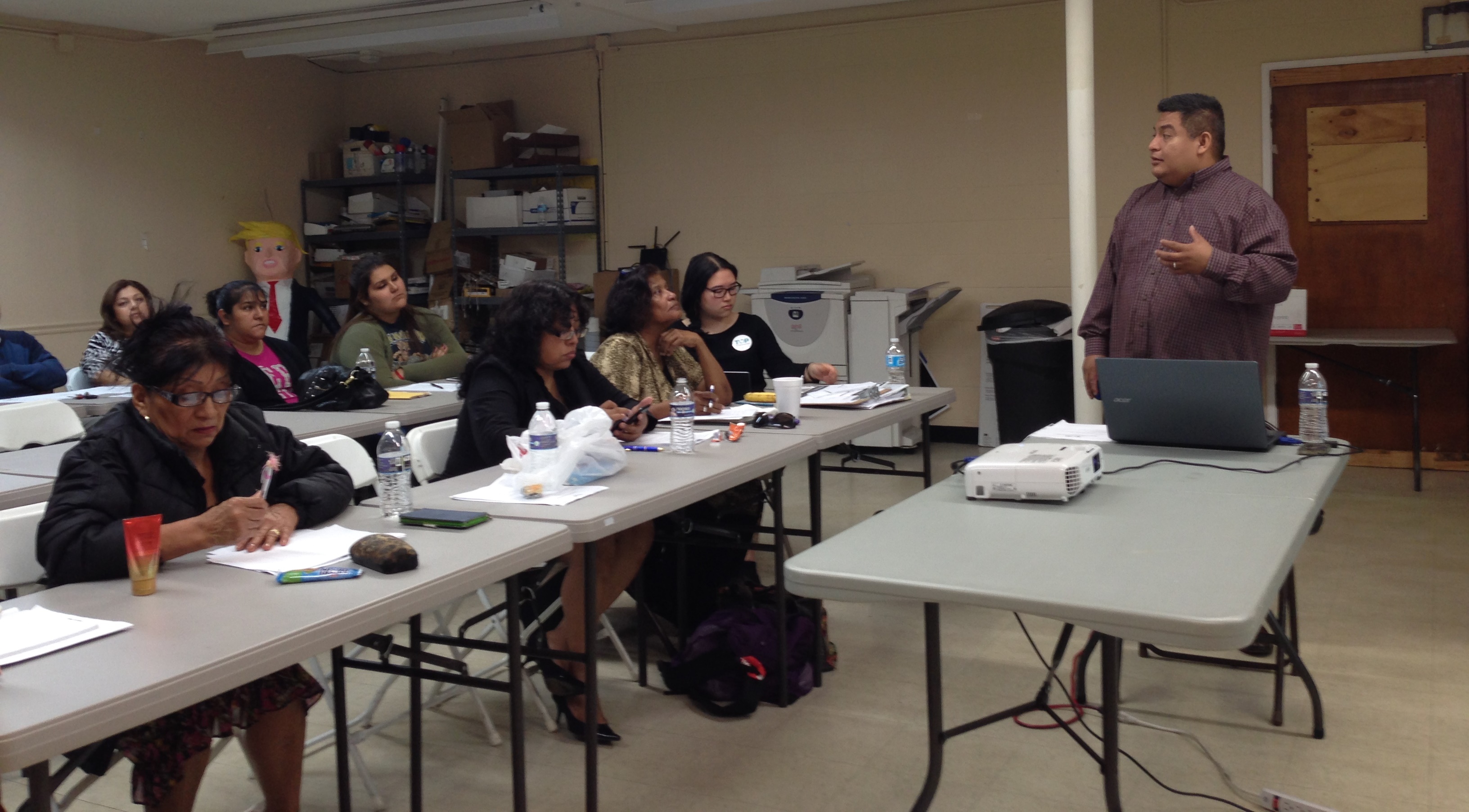Texas Organizing Project's Alain Cisneros (right) tells workshop participants about the deferred action programs, which are commonly known by the acronyms DACA and DAPA and would temporarily stop the potential deportation of undocumented immigrants who meet certain criteria established by the federal government.
