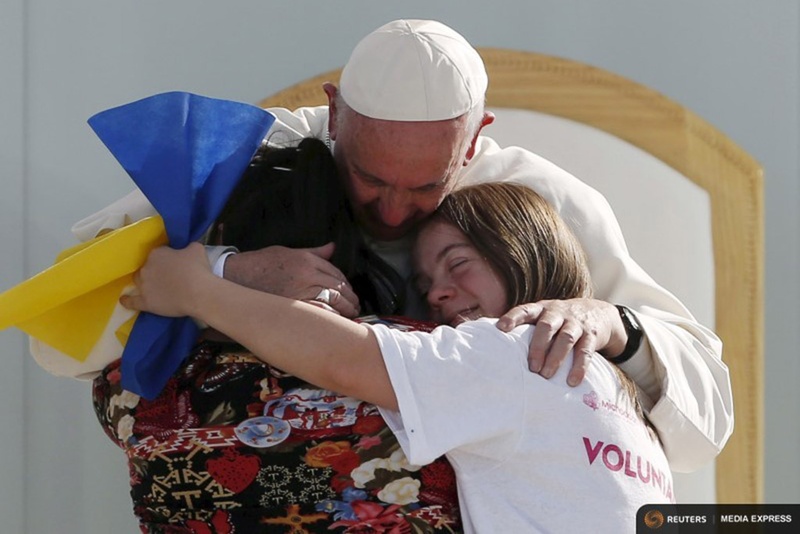 Pope Francis hugs two girls