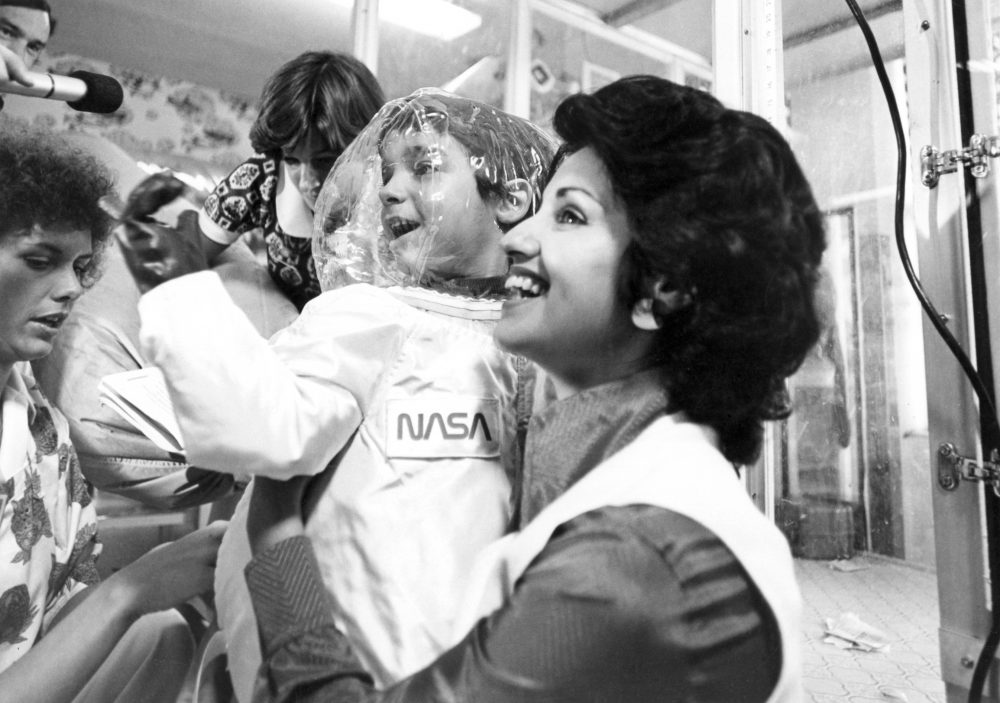 David Vetter in his mother's arms prior to his first walk in sterile "spacesuit" designed for him by NASA. July 29, 1977. (Photo Credit: Texas Children's Hospital)