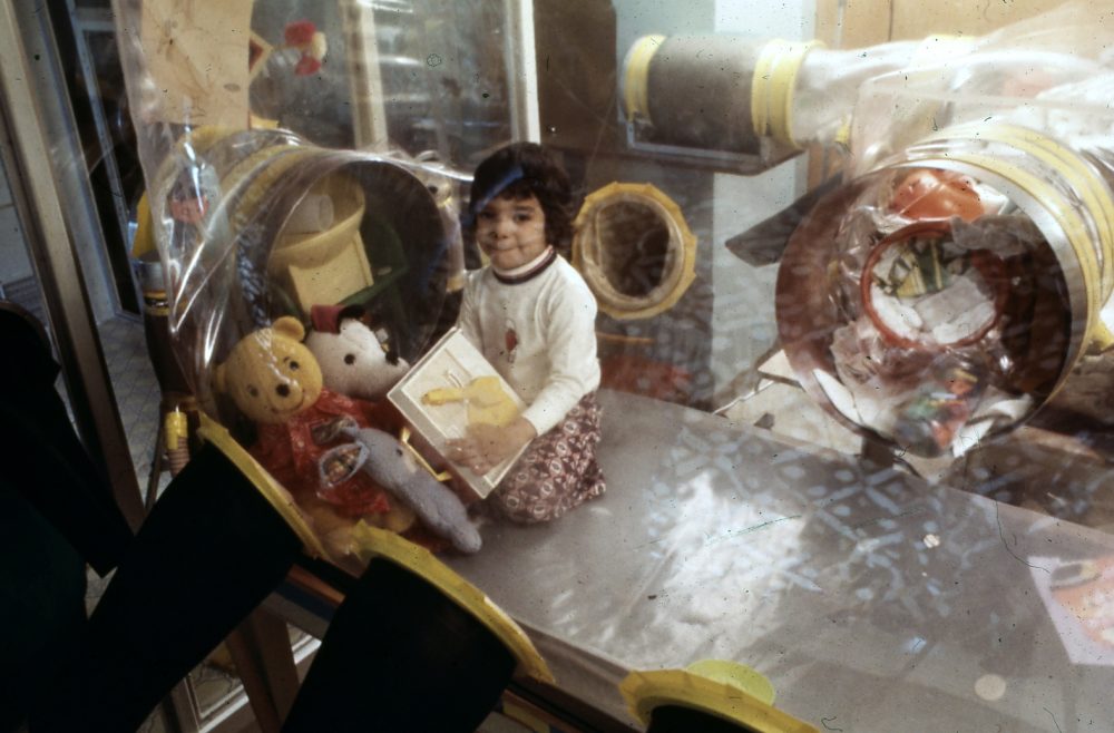 David plays with toys inside his isolator in 1975. (Photo Credit: Baylor College of Medicine)