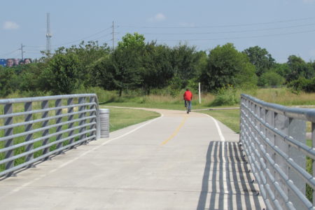 A cyclist on the White Oak Trail behind the University of Houston-Downtown