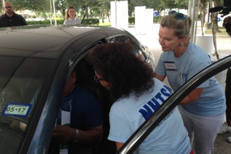 NHTSA workers check the car of Houston resident who decided to dropped by their community event.