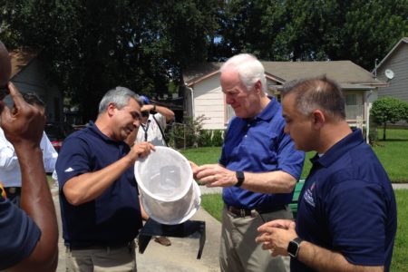 Doctor Mustapha Debboun, director of Harris County's Mosquito and Vector Control, U.S. Senator John Cornyn, and Doctor Umair Shah, executive director of Harris County Public Health examine a mosquito trap in a south Houston neighborhood.