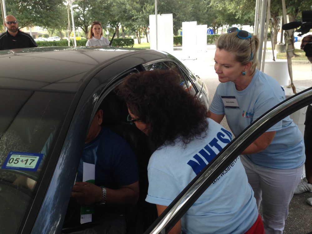 NHTSA workers check the car of Houston resident who decided to dropped by their community event.