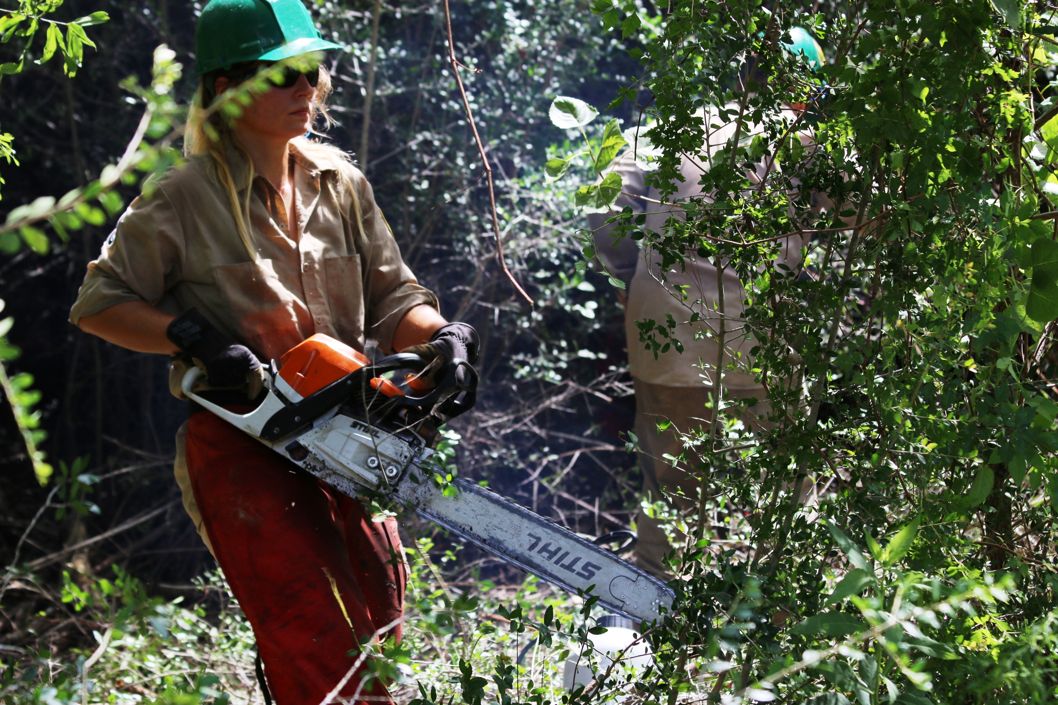 Texas Conservation Corps member Aneta Tyminski clearing brush in the Houston Arboretum