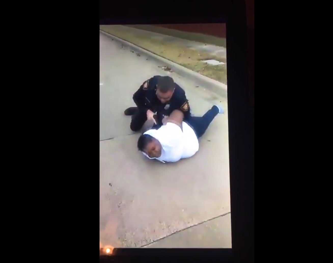 An identified Fort Worth police officer holds Jacqueline Craig on the ground. This image comes from a Facebook Live video that has since gone viral.
