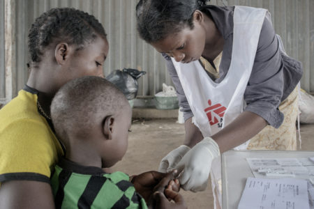 An MSF (Médecins Sans Frontières) nurse performs the so called malaria "rapid test".  MSF's guidelines recommend the use of rapid malaria test to detect malaria parasite in the patient's blood.