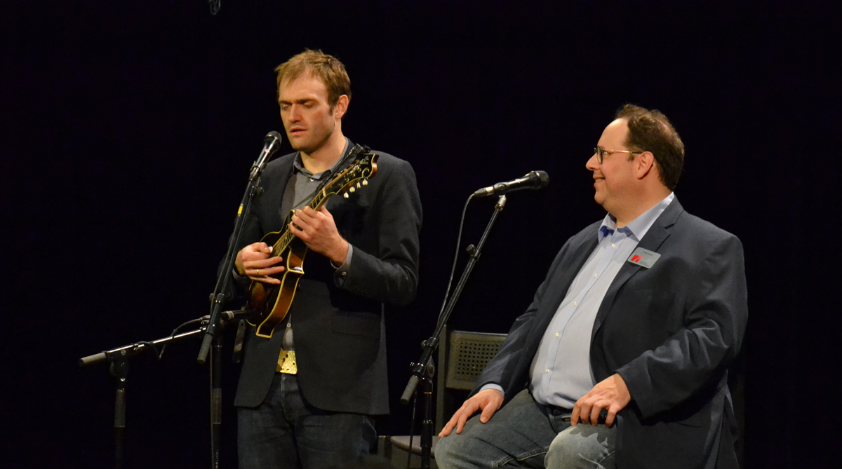 Chris Thile, host of "A Prairie Home Companion" performs onstage as "Houston Matters" host Craig Cohen looks on. Thile performed at an event for Houston Public Media donors on Jan. 22, 2017. (Photo: Fujio Watanabe, Houston Public Media)