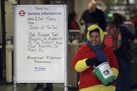 A woman collecting money for charity stands next to a quote written on an information board at Tower Hill underground train station, written in defiance of the previous day's attack in London, Thursday, March 23, 2017.  On Wednesday a man went on a deadly rampage, first driving a car into pedestrians then stabbing a police officer to death before being fatally shot by police within Parliament's grounds in London. (AP Photo/Matt Dunham)