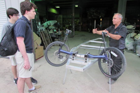 Mechanic Shimon Atzil (right) helped students fabricate the chassis at his southwest Houston auto body shop. The car features modified bicycle parts.
