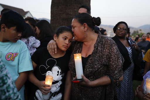Betty Rodriguez, right, comforts her granddaughter Giselle, 11, during a prayer service held to honor the shooting victims at North Park Elementary School, Monday, April 10, 2017, in San Bernardino, Calif. A man walked into his estranged wife's elementary school classroom in San Bernardino and opened deadly fire on Monday.  