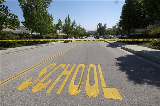 A police yellow tap is seen outside North Park School after a shooting ,Monday, April 10, 2017, in San Bernardino, Calif.. An apparent murder-suicide inside an elementary school classroom in San Bernardino left two adults dead, including a teacher, and two students wounded, police and school officials said. 
