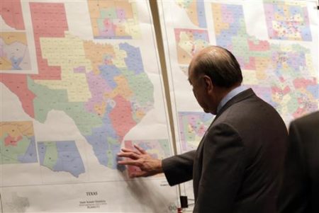 May 30, 2013 file photo, Texas state Sen. Juan "Chuy" Hinojosa looks at maps on display prior to a Senate Redistricting committee hearing in Austin, Texas.