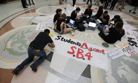 Students gather in the Rotunda at the Texas Capitol to oppose SB4, an anti-"sanctuary cities" bill that already cleared the Texas Senate and seeks to jail sheriffs and other officials who refuse to help enforce federal immigration law, as the Texas House prepares to debate the bill, Wednesday, April 26, 2017, in Austin, Texas.  Many sheriffs and police chiefs in heavily Democratic areas warn that it will make their jobs harder if immigrant communities, including crime victims and witnesses,  become afraid of police.