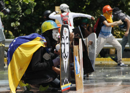 Anti-government protesters face off with Bolivarian National Guard during an opposition march in Caracas, Venezuela, Wednesday, May 10, 2017. Opponents of President Nicolas Maduro attempted to march to the Supreme Court to protest its decision to gut the opposition-controlled congress of its powers _ a ruling that was quickly rescinded under a barrage of international criticism but that set off weeks of political unrest that have left some three dozens killed. (AP Photo/Ariana Cubillos)