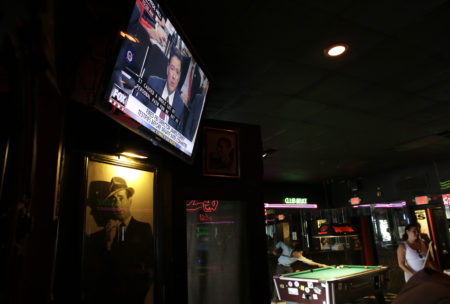 A television shows testimony by former FBI director James Comey before the Senate Intelligence Committee as patrons play pool at Mac's Club Deuce, Thursday, June 8, 2017, in Miami Beach, Fla.