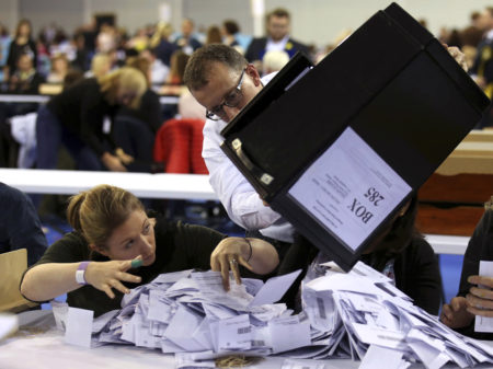 Ballot boxes are emptied to be counted for the general election in Glasgow, Scotland.