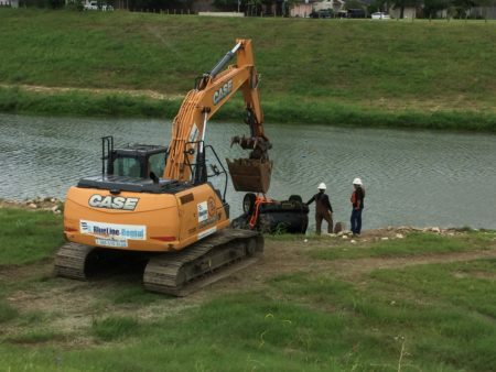 A crew from Huffman Contractors LLC works on the first day of the expansion of the program at Brays Bayou, southeast of downtown Houston.