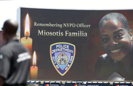 A security guard stands at attention as New York Police Department officer Miosotis Familia is memorialized before the start of a baseball game between the New York Yankees and the Toronto Blue Jays in New York, Wednesday, July 5, 2017. Familia was killed in an "unprovoked attack," in the Bronx borough of New York, according to the NYPD Commissioner.