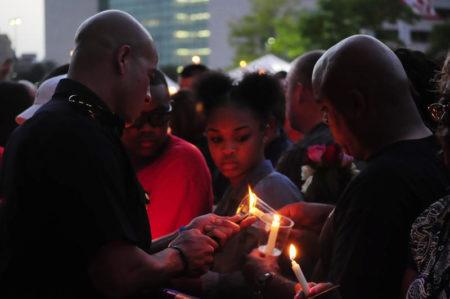 A Dallas police officer lights candles for attendees of a vigil on July 11, 2016, following the deadly attack on law enforcement in the city.