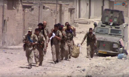 This frame grab from video released Tuesday, July 4, 2017, and provided by Furat FM, a Syrian Kurdish activist-run media group, shows U.S.-backed Syrian Democratic Forces (SDF) fighters in the eastern side of Raqqa, Syria. The SDF forces have breached the wall around Raqqa's Old City, the U.S. military said Tuesday, marking a major advance in the weeks-old battle to drive Islamic State militants out of their self-declared capital. (Furat FM, via AP)