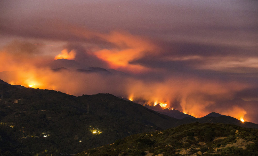 This photo provided by Eliot Oppenheimer, taken late in the evening Sunday, July 9, 2017, shows the Whittier fire burning in the mountains west of Santa Barbara, Calif. In Southern California, thousands of people remained out of their homes as a pair of fires raged at different ends of Santa Barbara County. The fires broke out amid a blistering weekend heat wave that toppled temperature records. 