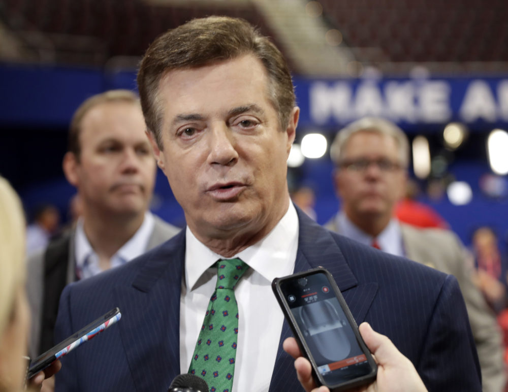 In this July 17, 2016 file photo, Trump Campaign Chairman Paul Manafort talks to reporters on the floor of the Republican National Convention at Quicken Loans Arena in Cleveland as Rick Gates listens at back left. Emails obtained by The Associated Press shed new light on the activities of a firm run by Donald Trump's campaign chairman. They show it directly orchestrated a covert Washington lobbying operation on behalf of Ukraine's ruling political party, attempting to sway American public opinion in favor of the country's pro-Russian government. Manafort and his deputy, Rick Gates, never disclosed their work as foreign agents as required under federal law.