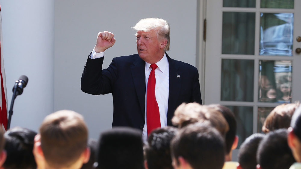 President Trump pumps a fist during a speech in the Rose Garden of the White House July 26. On Wednesday, he's unveiling legislation that would curtail legal immigration