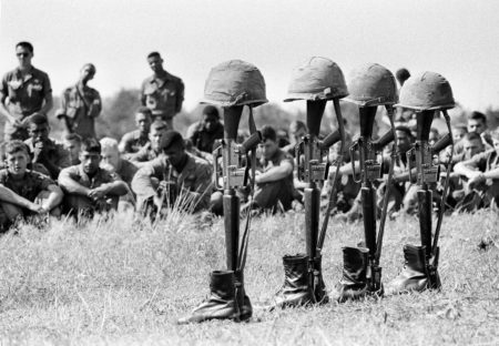 U.S. soldiers bow their heads at memorial services at Lai Khe, Vietnam, Dec. 17, 1965, for comrades killed in action the week before. The rifles, helmets and boots belong to the seven casualties killed during a search and destroy operation in the jungle west of Lai Khe.
