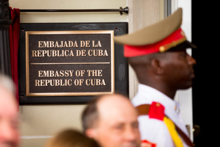 A member of the Cuban honor guard stands next to a new plaque at the front door of the newly reopened Cuban embassy in Washington, Monday, July 20, 2015. Cuba's blue, red and white-starred flag was hoisted Monday at the country's embassy in Washington in a symbolic move signaling the start of a new post-Cold War era in U.S.-Cuba relations.