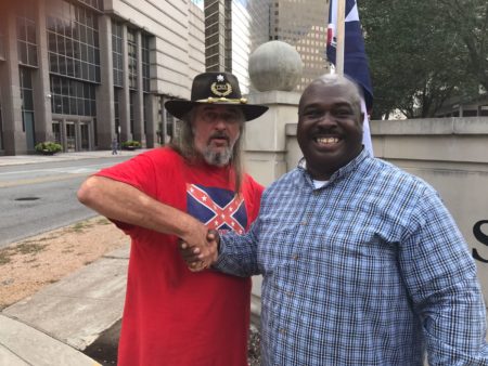 Counter-protester Vince Powers (L) and rally participant, Douglas Earl Brown (R) share a moment of comradery before the start of the "Destroy the Confederacy" rally.