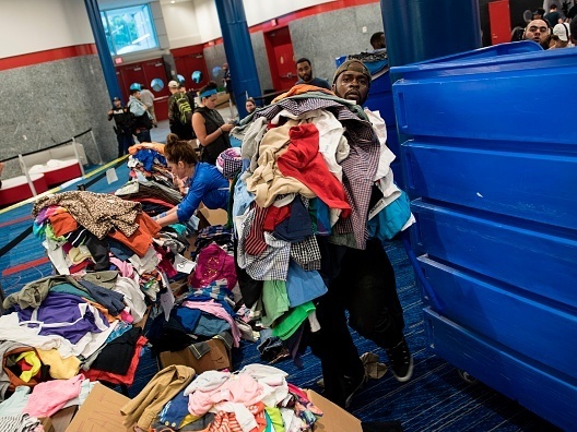 Volunteers sort through donated clothing at a shelter in the George R. Brown Convention Center during the aftermath of Hurricane Harvey on August 28 in Houston, Texas.