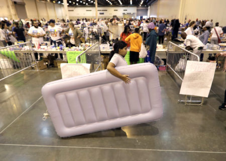 A girl carries an air mattress at a shelter setup inside NRG Center for flood victims of Harvey Wednesday, Aug. 30, 2017, in Houston. (AP Photo/David J. Phillip)