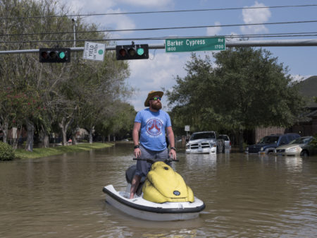 Rabon Raulerson stands on the personal watercraft he has been using to help flood victims on the west side of Houston check out their homes and salvage what they can.