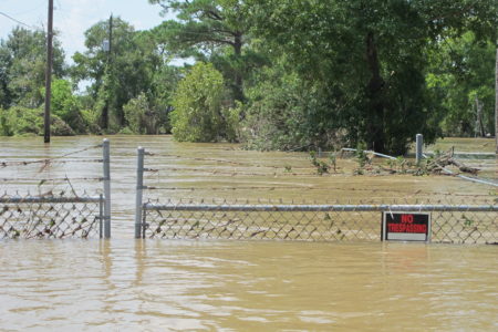 In this Aug. 31, 2017 file photo, a barbed-wire fence encircles the Highlands Acid Pit that was flooded by water from the nearby San Jacinto River as a result from Harvey in Highlands, Texas. Floodwaters have inundated at least five highly contaminated toxic waste sites near Houston, raising concerns that the pollution there might spread.