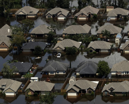 Homes are surrounded by water from the flooded Brazos River in the aftermath of Hurricane Harvey Friday, Sept. 1, 2017, in Freeport, Texas.