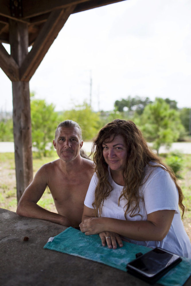 Erik Ryan and Mia Reynolds from San Leon, Texas, wait on hold with FEMA at their campsite at Bastrop State Park in Texas on Sunday. Running out of money and resources, they were relieved to hear Texas Gov. Greg Abbott's announcement that Texas State Parks were open for the month of September for evacuees, free of charge.