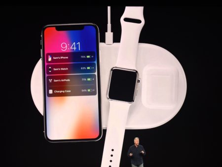 Apple executive Philip Schiller presents a wireless charging system, displayed with the new iPhone X and Apple Watch alongside cordless headphones called AirPods.
