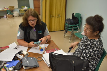 Nurse practitioner Jean Bernhardt of Massachusetts General Hospital (left) speaks with patient Magdalena O’Neill at a Project Hope medical clinic in Rosenberg, TX