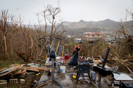 Juan Pablo Santos cleans up the debris from his shed near Aibonito, Puerto Rico, after it was destroyed by Hurricane Maria.