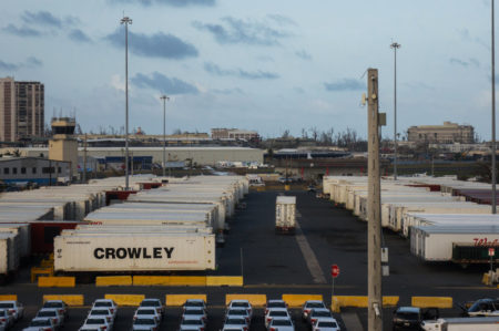 Crowley shipping containers with running refrigeration systems are lined up at in the port of San Juan, Puerto Rico. They've been there for days, goods locked away inside.